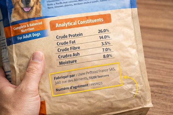 Lecture des informations nutritionnelles sur un paquet de croquettes